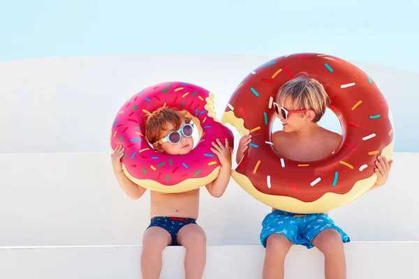 快乐的孩子在眼镜和游泳裤与甜甜圈橡胶戒指准备暑假 — 图库照片
