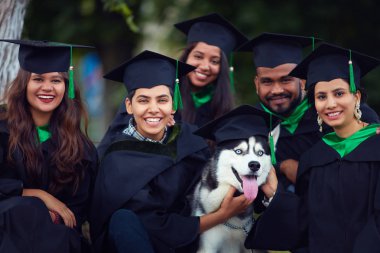Mezuniyet önlük ile evde beslenen hayvan köpek mutlu Hint öğrenciler arkadaşlar portresi