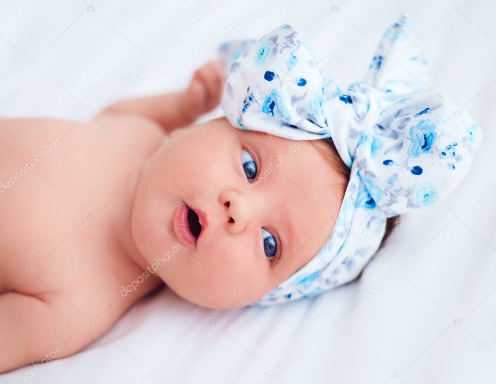 cute two weeks old, newborn baby girl expressing curiosity, exploring a new world around her