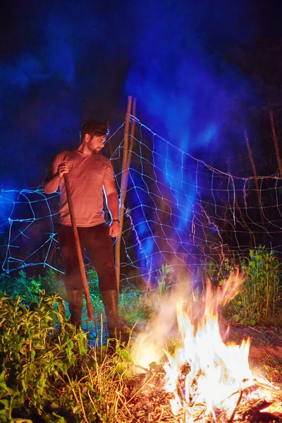 man burning brushwood on fire, seasonal cleaning of the countryside area, village lifestyle