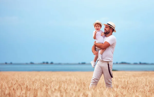 幸福的父亲和幼儿的儿子走过成熟的麦田 — 图库照片