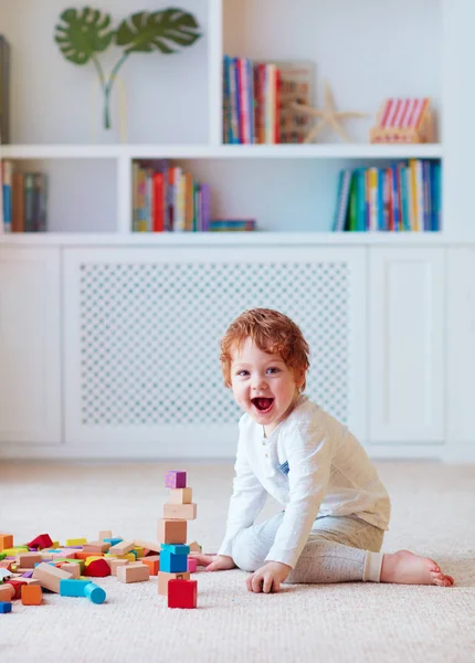 Bonito criança bebê menino brincando com blocos de madeira, construindo uma torre alta — Fotografia de Stock