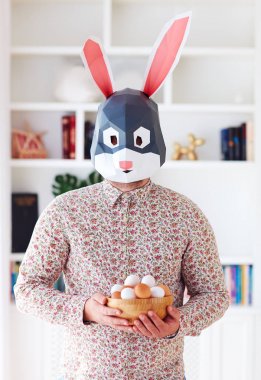 evde yumurta dolu bir kase tutan genç aduly Bunny tavşan adam