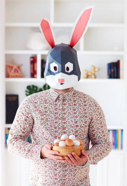 Jovem coelho coelho adulto homem segurando uma tigela cheia de ovos em casa — Fotografia de Stock