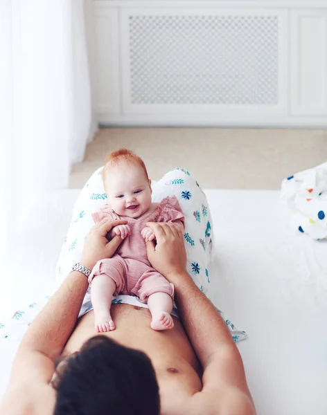 若い父親はベッドの中でかわいい幼児の赤ちゃん娘と一緒に遊んで、自宅で — ストック写真
