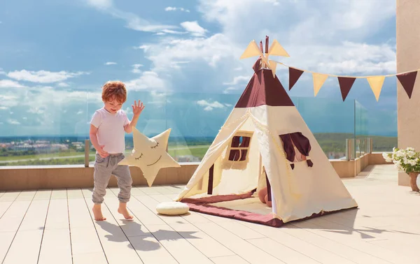 Szczęśliwy młody chłopak, dziecko gra w pobliżu tekstylny namiot wigwam na letnim patio — Zdjęcie stockowe