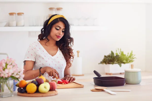 Vacker ung indisk kvinna skära grönsaker på köket, hälsosam kost — Stockfoto