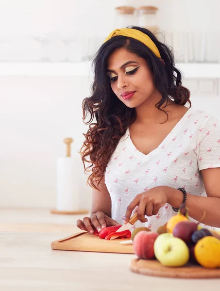 Vacker ung indisk kvinna skära grönsaker på köket, — Stockfoto
