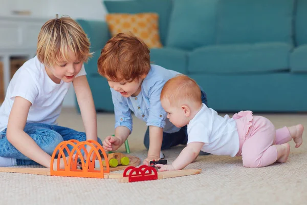 Crianças bonitos, irmãos jogando brinquedos juntos no tapete em casa — Fotografia de Stock
