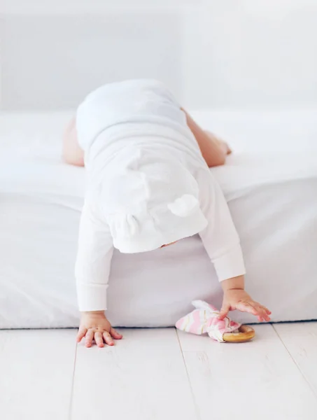Niedliches Säuglingsmädchen, das aus dem Bett fällt, acht Monate alt — Stockfoto