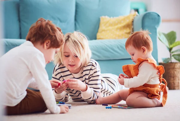 Crianças bonitos, irmãos brincando juntos no chão em casa — Fotografia de Stock