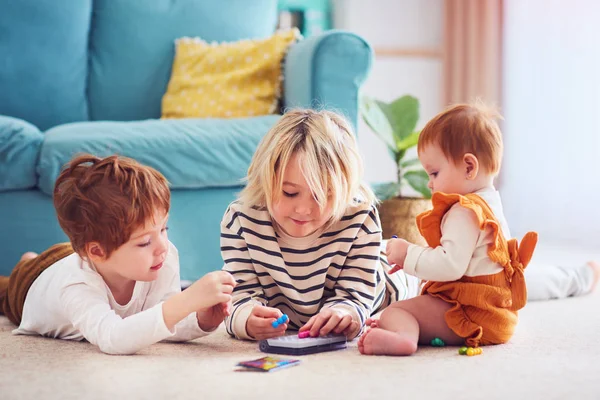 Mignons enfants, frères et sœurs jouer ensemble sur le sol à la maison — Photo