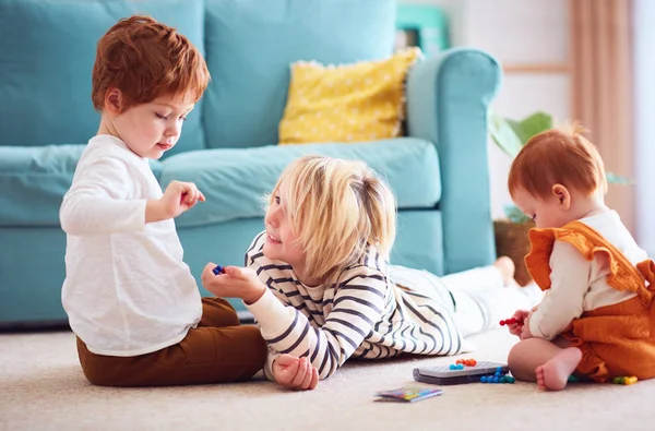 Crianças bonitos, irmãos brincando juntos no chão em casa — Fotografia de Stock