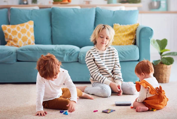 Sevimli çocuklar, kardeşler evde yerde oynarken — Stok fotoğraf