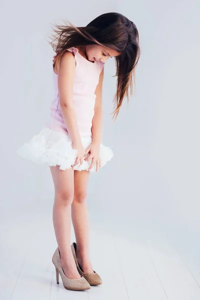 Beautiful young girl, kid trying on high heel shoes — Stock Photo, Image