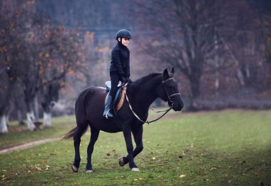 Delikanlı, çocuk ata binme dersi alıyor, binicilik sporu, binicilik kıyafeti...