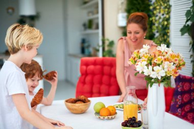 Mutlu aile sofrası evdeki yaz bahçesinde öğle yemeği için hazırlanıyor.