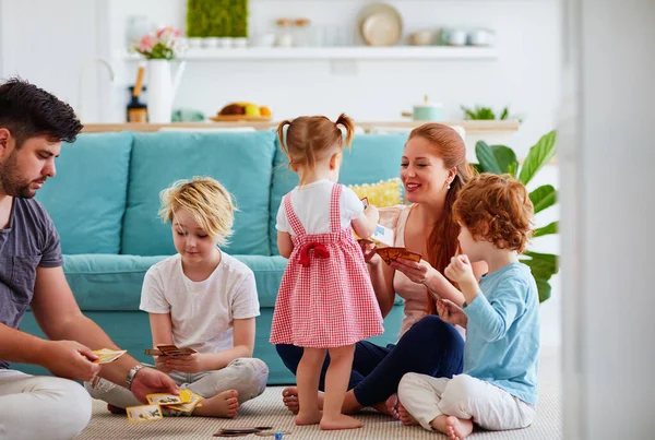 幸せな家族が家の床で一緒にトランプゲームをしています — ストック写真