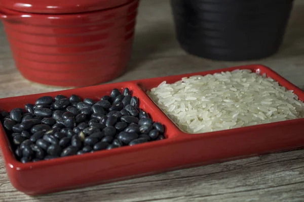 Arroz Feijão Preto Bruto Recipiente Vermelho Fundo Madeira — Fotografia de Stock