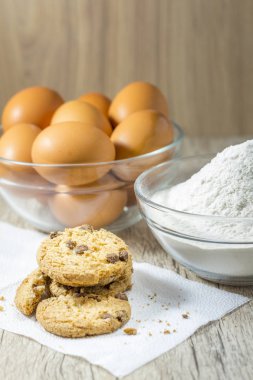 Ev yapımı yulaf ezmeli kurabiye yumurta arka plan ile eski tabloda ahşap tahta üzerinde. Sağlıklı gıda kavramı. 