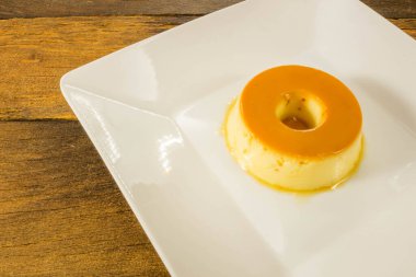 Sütlü puding ya da pudim de leite. Brezilya usulü ev yapımı karamel kremalı puding. Ahşap arka planda geleneksel Brezilya turtası