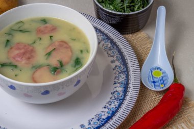 Caldo Verde Çorbası, Portekiz mutfağında yeşil sebzeli ve üzerine dilimlenmiş seramik kase ve bir parça ekmek ve biberli popüler bir çorbadır. Üst Görünüm