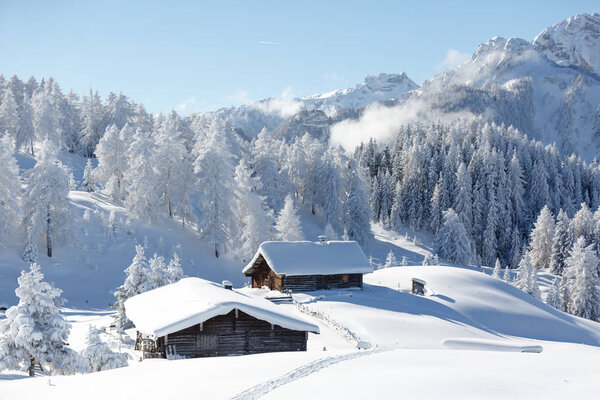 Beautiful winter mountain landscape with traditional mountain hut in Austrian Alps