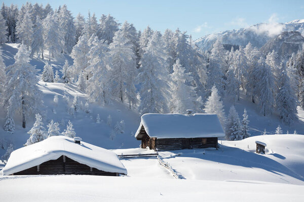 Winter in Austrian Alps. Traditional alpine hut covered with a snow