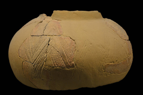 An Ancient Stone Age bowl from 8,000 years ago, found in Sicily, decorated with a geometric impressed design. Isolated against a white background