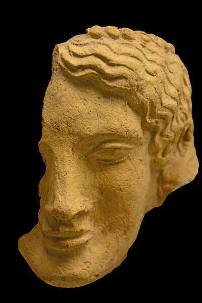 Ancient Greek Sculpture of a woman's head with wavy hair and a calm expression. Dated to 600BC