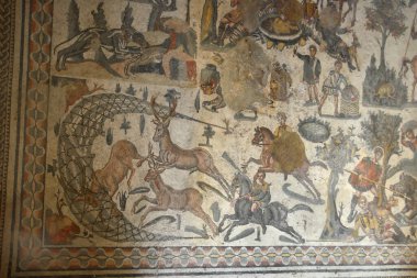 Geyik avının Antik Roma Mozaiği. Ağaçlara bağlanmış ve taşlarla ağırlaşmış geyikleri kovalayan süvarileri gösteriyor. Sicilya 'daki Villa Romana del Casale' deki Little Hunt odasından.