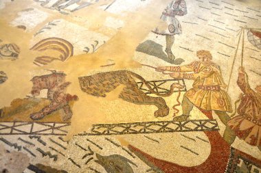 Antik Roma mozaik sahnesinde Romalı bir adam Büyük Av Koridorunda bir kaplanı kontrol etmeye çalışıyordu. UNESCO listesinden Villa Romana del Casale, Sicilya