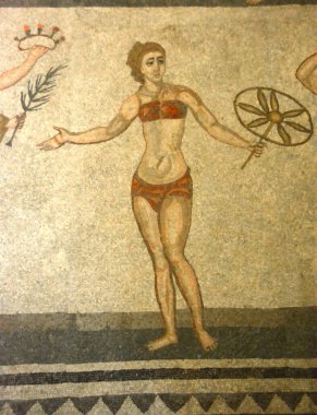 Antik Roma mozaiğinde bikinili bir kız bir oyun kazandı, bir gül tacı ve bir yaprak aldı ve bir yandan da sembolik çiçek ödülünü başka bir kıza verdi. UNESCO listesinden Villa Romana del Casale, Sicilya