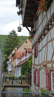 Ortaçağ kasabasında Swabian Jura bölgesinde küçük bir kanalın yanına inşa edilmiş yarı keresteli Alman binası. Bir sulama kutusu pencere kutuları için su sağlar