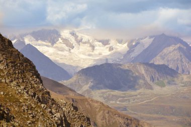 Bernese Alpleri 'ndeki Aletschhorn buzulları, İtalya sınırındaki bulutlu gökyüzünün altında güneyden görülüyordu.