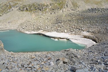 İklim ısındıkça dağlardaki bir buzulun buzdağından kopan buzdağları..