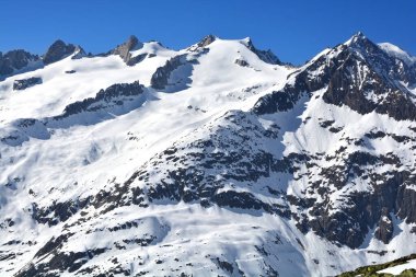 Aletsch buzulunun üzerindeki Bernese Alplerinde Schinhorn, Sattelhorn ve Aletschhorn (soldan sağa). Kışın güneşli bir günde