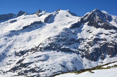 Aletsch buzulunun üzerindeki Bernese Alplerinde Schinhorn, Sattelhorn ve Aletschhorn (soldan sağa). Kışın güneşli bir günde