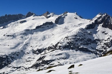 Aletsch buzulunun üzerindeki Bernese Alplerinde Schinhorn, Sattelhorn ve Aletschhorn (soldan sağa). Kışın güneşli bir günde