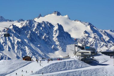 Arka planda Aiguille du Tour ile Verbier 'de, Lac des Vaux bölgesinde kayak yapmak. Mont Gele 'ye erişimi olan Attelas teleferik istasyonu.