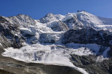 Zinalrothorn (sağda), Blanc de Moming ve Schallihorn (solda) İsviçre Alpleri 'ndeki Zinal tatil beldesinin tepesinde.