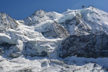 Zinalrothorn (sağda) ve Blanc de Moming dağlık Zinal tatil beldesinin üstündeki İsviçre Alplerinde