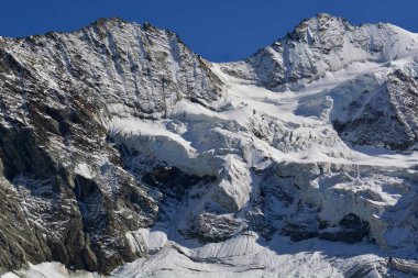 Schallihorn ve Pointe Sud du Moming (sağda) dağlık Zinal tatil beldesinin üstündeki İsviçre Alplerinde