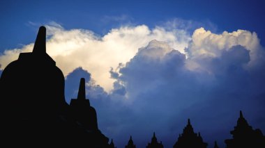 Endonezya 'daki Borobudur Tapınağı, epik bulutlu gün batımı, UNESCO dünya mirası alanı, yumuşak odak, film tahılları, seyahat kavramı, ruhanilik ve barış