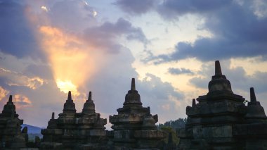 Doğu Java, Endonezya 'daki Borobudur Tapınağı' nda gün batımı muhteşemdi. Tepelerin üzerinde mavi ve turuncu gökyüzü, yeşil ormanlar ve stupa, seyahat noktası, UNESCO Dünya Mirası Bölgesi