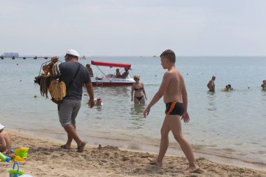 Evpatoria, Crimea - 29 Haziran 2018: Balık satıcı resort kasaba Evpatoria, Crimea merkezi plaj boyunca yürüyor