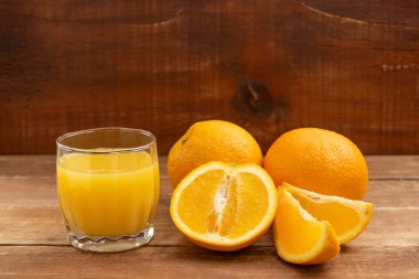 Portakallar tahta bir masanın üzerinde yatıyor..