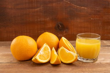 Portakallar tahta bir masanın üzerinde yatıyor..