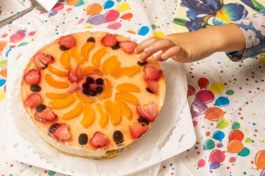 Bebek parmağını doğum günü pastasına soktu.