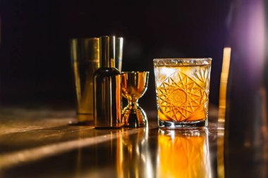 Üç renkli kokteyller büyük gözlüklü bir klasik bar ortamı içinde belgili tanımlık geçmiş bulanık içki şişeleri düzinelerce.